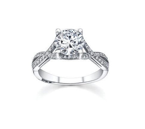 A platinum and diamond ring with melee diamonds surrounding a large round cut diamond.