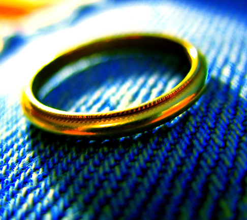 a plain gold ring on a blue fabric